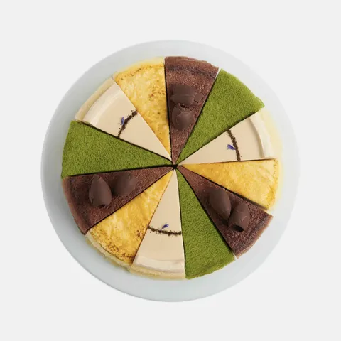 A top-down shot of a Lady M Slice of the Best: Classic Collection on top a white cake stand.