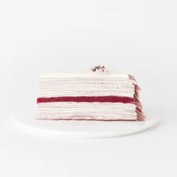 A thumbnail shot of a Lady M Lavender Mille Crêpes slice on top a white round plate.