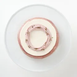 A top-down shot of a 6-inch Lady M Lavender Mille Crêpes on top a white cake stand.