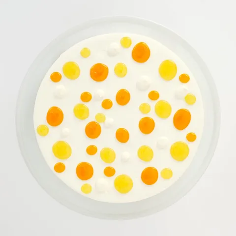 A top-down shot of a Lady M Mango Shortcake on top a white cake stand.
