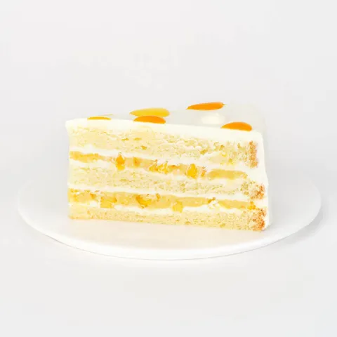 A thumbnail shot of a Lady M Mango Shortcake slice on top a white round plate.