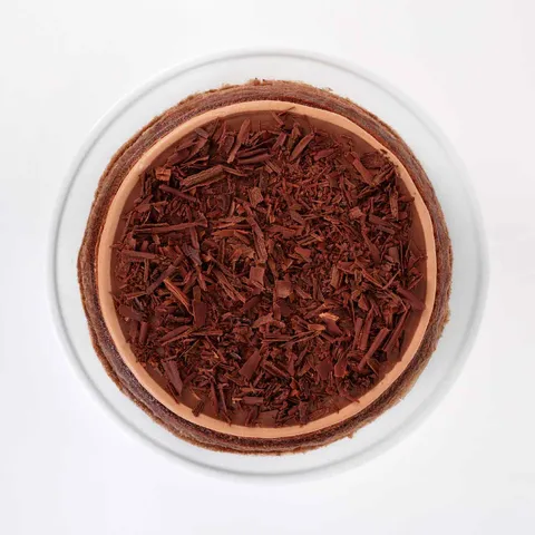 A top-down shot of a Lady M Amedei Chocolate Mille Crêpes on top a white cake stand.