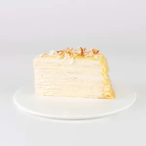 A slice of Lady M's Coconut Mille Crêpes on a white plate.
