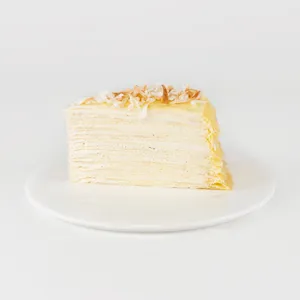 A slice of Lady M's Coconut Mille Crêpes on a white plate.