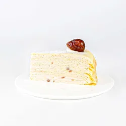 A thumbnail shot of a Lady M Marron Mille Crêpes slice on top a white round plate.