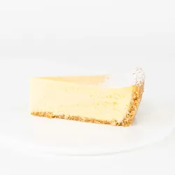 A thumbnail shot of a Lady M Passion Fruit Cheesecake slice on top a white round plate.