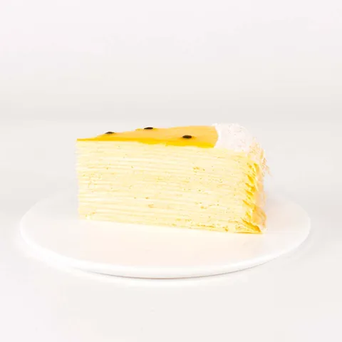 A thumbnail shot of a Lady M Passion Fruit Mille Crêpes slice on top a white round plate.
