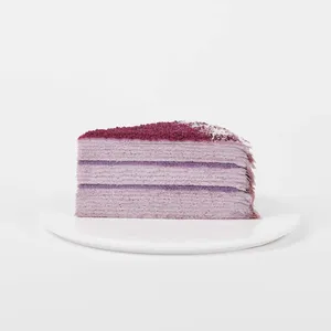 A thumbnail shot of a Lady M Purple Yam Mille Crêpes slice on top a white round plate.