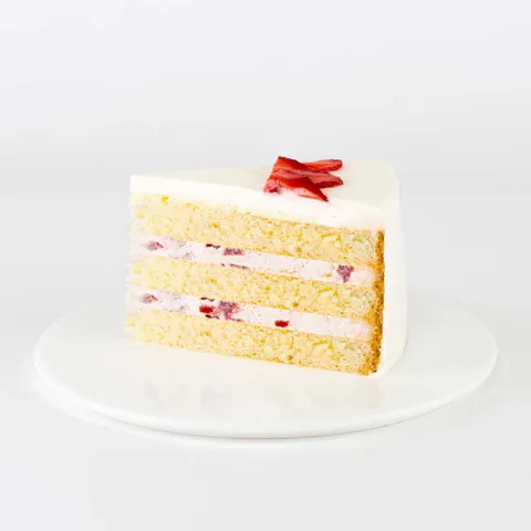 A thumbnail shot of a Lady M Strawberry Shortcake slice on top a white round plate.
