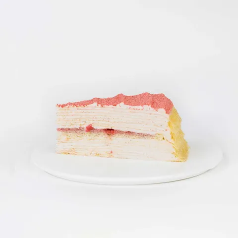 A thumbnail shot of a Lady M Strawberry Swirl Mille Crêpes slice on top a white round plate.