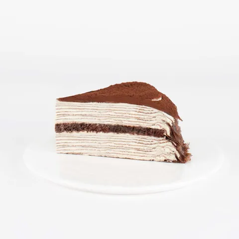 A thumbnail shot of a Lady M Tiramisu Mille Crêpes slice on top a white round plate.