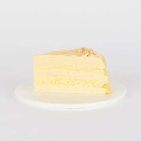 A thumbnail shot of a Lady M Tres Leches Mille Crêpes slice on top a white round plate.