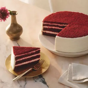 A Lady M Red Velvet with one slice served on a plate over a marble table top.