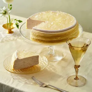 A Lady M Champagne Mille Crêpes with one slice served on a plate, set on top a white linen.