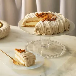 A Lady M Gâteau Aux Marrons with one slice served on a plate, set on top a marble table top.