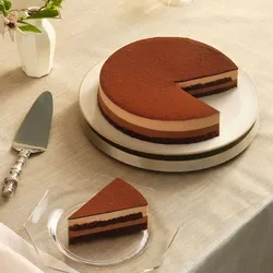 A Lady M Chocolate Arc-en-Ciel with one slice served on a plate over a beige linen.