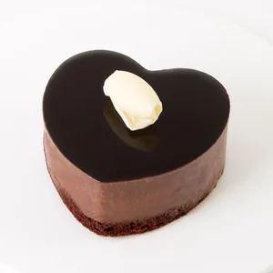 A thumbnail shot of a Lady M Couronne du Chocolat Heart cake on top a white round plate.