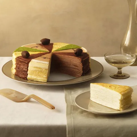 A Lady M Slice of the Best: Classic Collection with one slice served on a plate over a white linen.