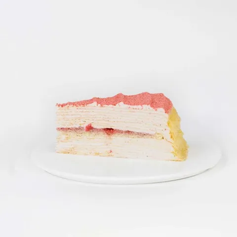 A slice of Lady M's Strawberry Swirl Mille Crêpes, on top a white round plate.