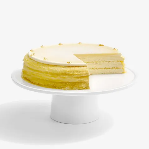 A thumbnail shot of sliced into Lady M Dassai Blue Mille Crêpes, on top a white cake stand.