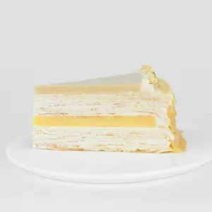 A thumbnail shot of Lady M's Jasmine Calamansi Mille Crêpes slice on a white round plate.