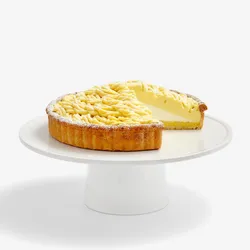 Thumbnail shot of a Lady M Sweet Corn Tart sliced into, on top a white cake stand.