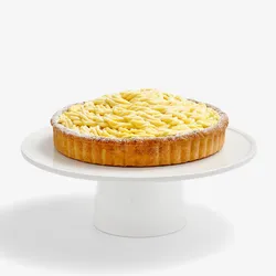 A thumbnail shot of a whole Lady M Sweet Corn Tart, on top a white cake stand.