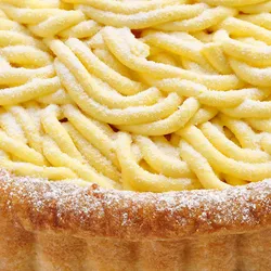 Close-up shot of Lady M's Sweet Corn Tart. Shortbread crust, layers of sweet corn mousse, and cream.