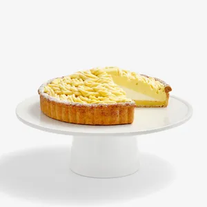 Thumbnail shot of a Lady M Sweet Corn Tart sliced into, on top a white cake stand.