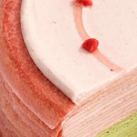A close-up shot of Lady M's Strawberry Matcha Mille Crêpes. Layers of strawberry and matcha crêpes.