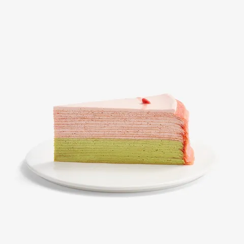 A thumbnail shot of Lady M's Strawberry Matcha Mille Crêpes slice on top a white round plate.