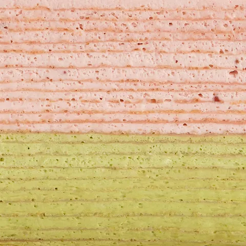 Detail shot of Lady M's Strawberry Matcha Mille Crêpes. Layers of strawberry and matcha crêpes.