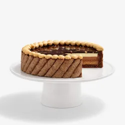 A thumbnail shot of Lady M's Noisettes Chocolat cake sliced into, on top of a white cake stand.