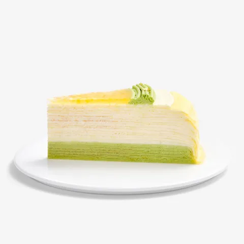 A slice of Lady M's Yuzu Matcha Mille Crêpes on top of a small round white plate.