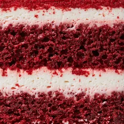 Close-up of rich layered red velvet cake.