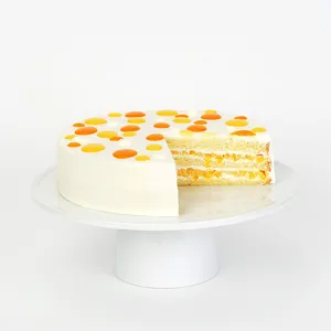 Mango shortcake with cream frosting, dotted top, and a slice revealing mango-filled layers.