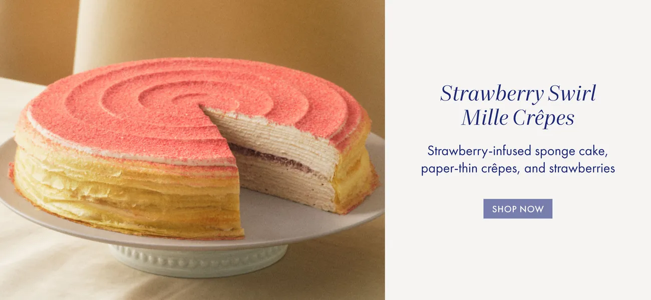 Lady M Strawberry Swirl Mille Crêpes: layered cake, pink swirl, sliced view of strawberry sponge/filling.