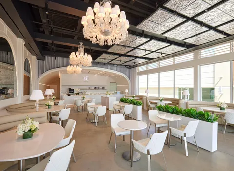 Lady M Houston Westchase: crystal chandeliers, natural light, white round tables, arched cake/ice cream/coffee counter. Elegant.