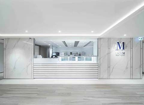 Lady M Central Stanley St HK: elegant white marble, sleek counter, glass displays, blue Lady M logo.