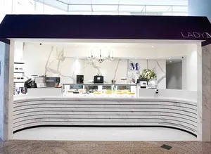 Lady M Quarry Bay HK kiosk: navy awning, white "LADY M", marble walls, striped counter, colorful cakes, blue logo, crystal light.