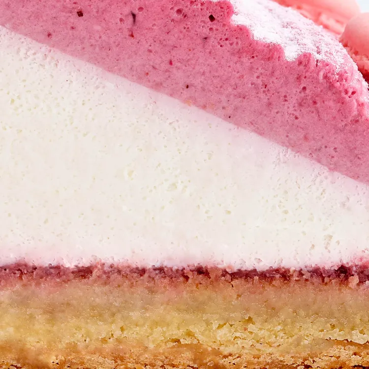 Close up image of a Berry Mont Blanc Tart slice showcasing the tart crust, fresh whipped cream, and the four-berry mousse on top.