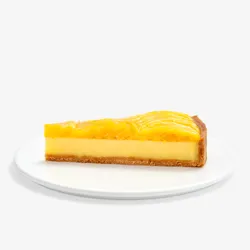 Slice of Lady M’s Tarte à la Mangue with golden crust, passion fruit filling, and glazed mango.