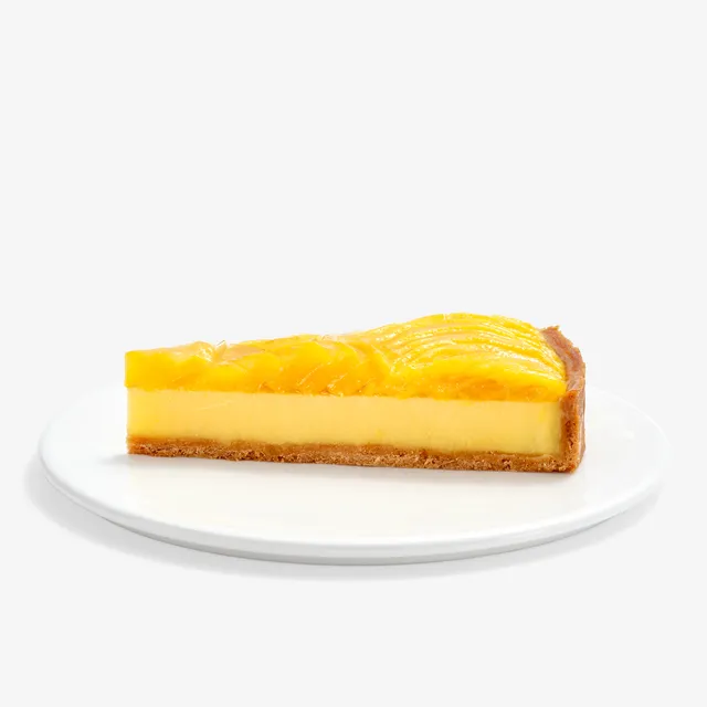 Slice of Lady M’s Tarte à la Mangue with golden crust, passion fruit filling, and glazed mango.