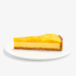 Slice of Lady M’s Tarte à la Mangue with golden crust, passion fruit filling, and glazed mango.
