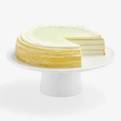 Lady M Pandan Kaya Mille Crêpes sliced, showing crêpe layers, pandan glaze, cream, and coconut flakes.