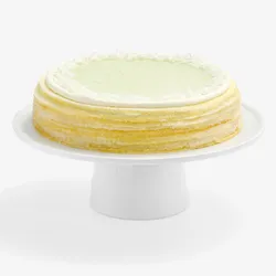 Whole Lady M Pandan Kaya Mille Crêpes with golden layers, green glaze, cream, and coconut flakes.
