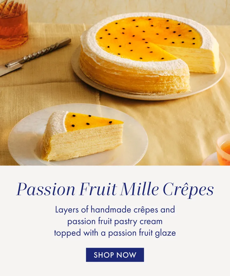 Lady M's layered Passion Fruit Mille Crêpes topped with fruit glaze and seeds, slice shown.
