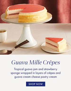 A Guava Mille Crêpes cake on a cake stand, with a slice cut and served on a plate.