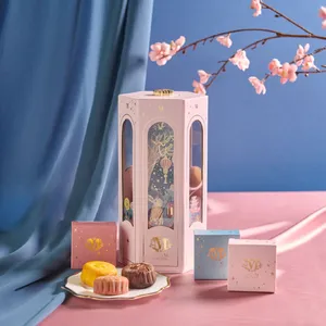 An ornate pink Lady M lantern is displayed with three colorful mooncakes on a plate in front.
