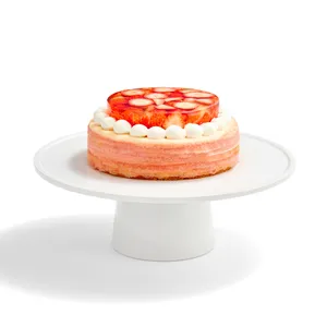 An Oishii Berry Trois Mille Crêpes cake with a strawberry gelée top, set on a white cake stand.